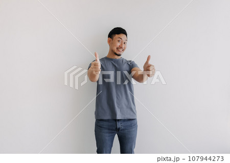 Happy smile asian man showing two thumbs up for good stand isolated on white Happy smile asian man showing two thumbs up for good stand isolated on white 107944273