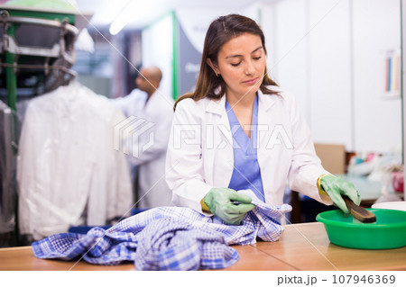 Experienced woman working in dry cleaner Experienced woman working in dry cleaner 107946369