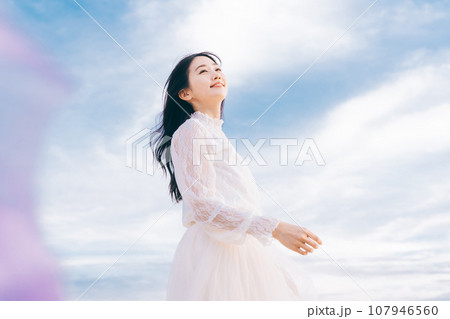 青空背景の女性ポートレート 107946560