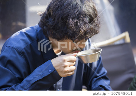 グランピング施設で朝、シェラカップでコーヒーを飲む男性 グランピング施設で朝、シェラカップでコーヒーを飲む男性 107948011