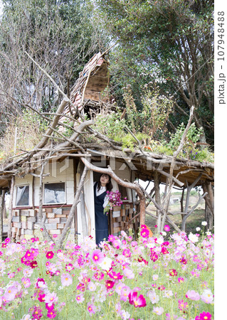 小さな小屋の玄関に立つ女性 107948488