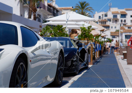 sports cars parked in a row on a street 107949584