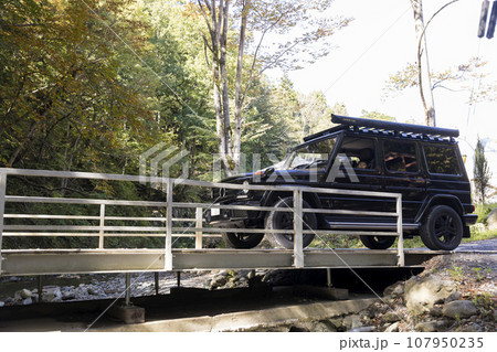 キャンプ施設に車で乗り入れる家族 橋を渡る四駆 キャンプ施設に車で乗り入れる家族 橋を渡る四駆 107950235