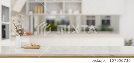 Empty space on a white marble kitchen tabletop in a modern white kitchen Empty space on a white marble kitchen tabletop in a modern white kitchen 107950730