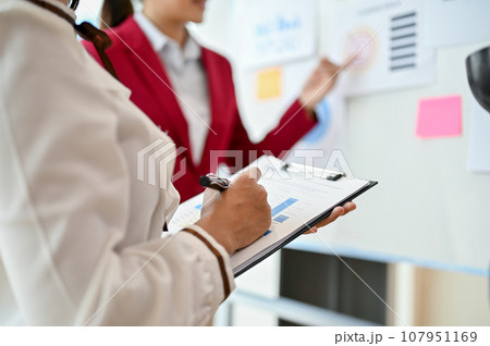 Close-up image of a professional businesswoman taking notes on documents Close-up image of a professional businesswoman taking notes on documents 107951169