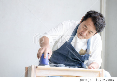 サンダーをかける男性 お家でDIY 107952003