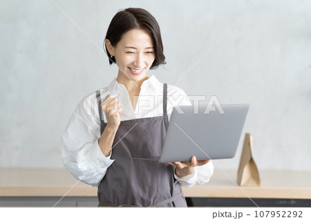 パソコンで注文を確認するカフェ店員 107952292