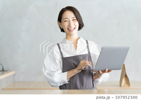 パソコンで注文を確認するカフェ店員 107952300