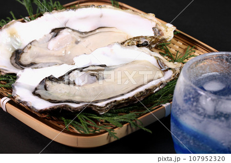 ザルの上の生牡蠣と焼酎の水割り 107952320