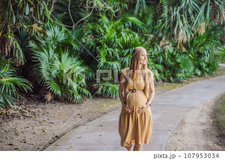 happy pregnant woman walking in the park happy pregnant woman walking in the park 107953034