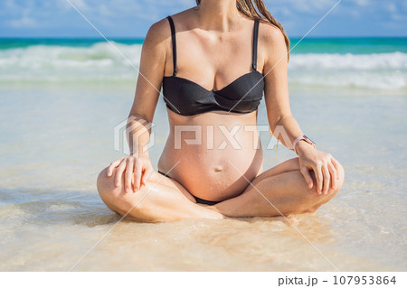 Expectant mother finds inner calm through meditation by the tranquil turquoise sea. A serene moment of pregnancy and peace Expectant mother finds inner calm through meditation by the tranquil turquoise sea. A serene moment of pregnancy and peace 107953864