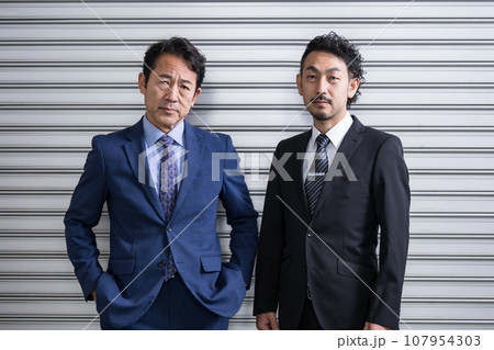 刑事ドラマや映画ののバディのイメージ シャッターの前に立つ 刑事ドラマや映画ののバディのイメージ シャッターの前に立つ 107954303