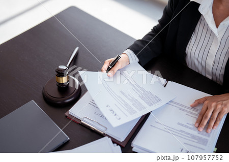 Lawyer businesswoman holding document to reading lawsuit and checking about financial business data while analysis about legislation agreement and terms data of business contract in law firm 107957752