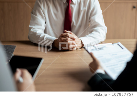 HR manager woman reading resume and writing data on tablet during job interview with male candidate HR manager woman reading resume and writing data on tablet during job interview with male candidate 107957757