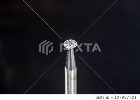 Diamond in jeweler tweezers Diamond in jeweler tweezers 107957781