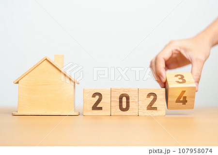 hand flip 2023 to 2024 block with house model. real estate, Home loan, tax, investment, financial, savings and New Year Resolution concepts 107958074
