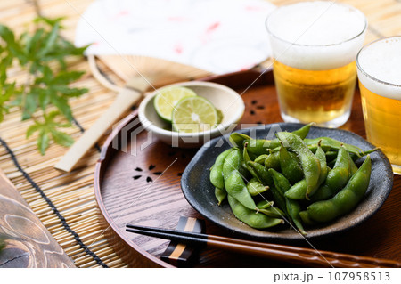 お盆にのせた枝豆とビール 酒の肴に（ お酒のおつまみイメージ ）えだまめの塩茹で 豆 枝まめ すだれ 107958513