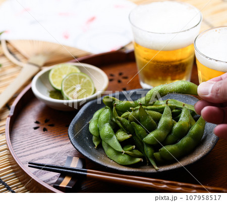 お盆にのせた枝豆とビール 酒の肴に( お酒のおつまみイメージ )えだまめの塩茹で 豆 枝まめ すだれ お盆にのせた枝豆とビール 酒の肴に( お酒のおつまみイメージ )えだまめの塩茹で 豆 枝まめ すだれ 107958517