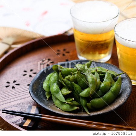 お盆にのせた枝豆とビール 酒の肴に（ お酒のおつまみイメージ ）えだまめの塩茹で 豆 枝まめ すだれ 107958518