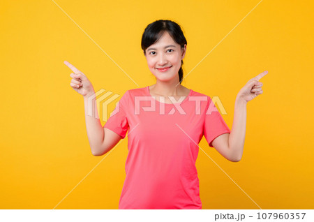 Portrait beautiful young asian sports fitness woman happy smile wearing pink sportswear posing exercise training workout isolated on yellow studio background. wellbeing and healthy lifestyle concept. Portrait beautiful young asian sports fitness woman happy smile wearing pink sportswear posing exercise training workout isolated on yellow studio background. wellbeing and healthy lifestyle concept. 107960357