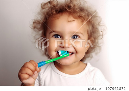 Toddler child with curly hair, brushing teeth.  107961872