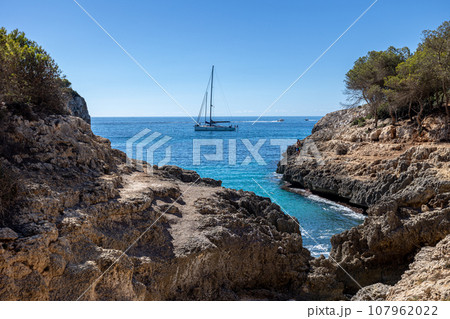 Beautiful view of hidden beach in Mallorca island. Scenic bay witch ship in mediterranean sea Beautiful view of hidden beach in Mallorca island. Scenic bay witch ship in mediterranean sea 107962022