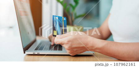 woman hand holding credit card and using laptop for online shopping while making order at home. Marketplace platform website, technology, ecommerce, digital banking and online payment concept woman hand holding credit card and using laptop for online shopping while making order at home. Marketplace platform website, technology, ecommerce, digital banking and online payment concept 107962161