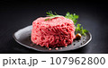 Fresh minced meat ground beef on a black plate. 107962800