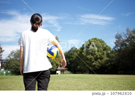 広くて綺麗な芝生の公園でバレーボールをして遊ぶ 107962810