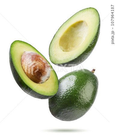 Ripe avocado and two halves flyon a white background. Isolated 107964187