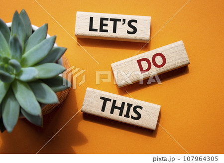 Lets do this symbol. Concept word Lets do this on wooden blocks. Beautiful orange background with succulent plant. Business and Lets do this concept. Copy space 107964305