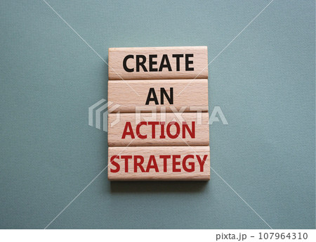 Create an action Strategy symbol. Wooden blocks with words Create an action Strategy. Beautiful grey green background. Businessman hand. Business and Create an action Strategy concept. Copy space. 107964310