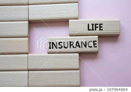 Life insurance symbol. Concept word Life insurance on wooden blocks. Beautiful pink background. Business and Life insurance concept. Copy space 107964864