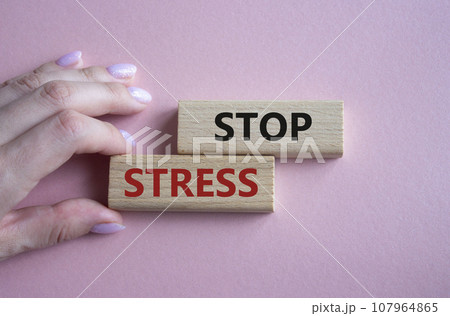 Stop Stress symbol. Concept word Stop Stress on wooden blocks. Businessman hand. Beautiful pink background. Business and Stop Stress concept. Copy space 107964865