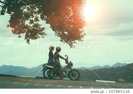 couples wearing safety helmet sitting on small enduro motorcycle against beautiful natural mountain scene at khaoyai national park thailand 107965116