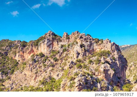 Mountain cliffs against sky with clouds Mountain cliffs against sky with clouds 107965917