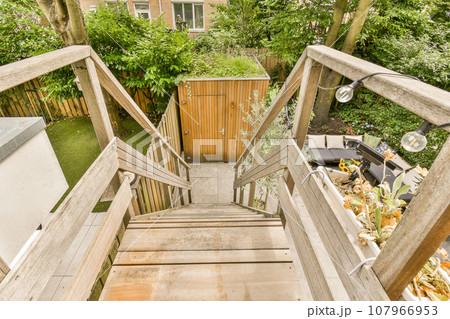 some stairs leading up to a house with trees in the back ground and bushes growing on either side of it 107966953