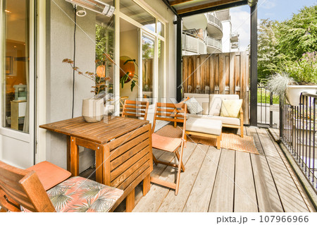 a patio with chairs and tables on the decking area, looking out to the backyard through the sliding glass door 107966966