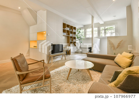 a living room with couches, chairs and a coffee table in the center of the room is white walls 107966977