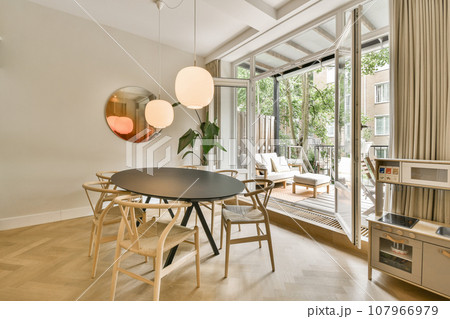 a dining table and chairs in a living room with sliding glass doors that open to the patio area, outside a dining table and chairs in a living room with sliding glass doors that open to the patio area, outside 107966979