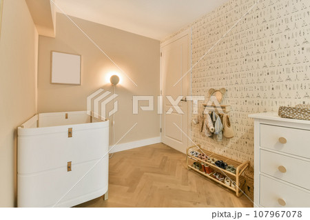 an empty room with white furniture and wallpapers on the walls there is a baby's cribt an empty room with white furniture and wallpapers on the walls there is a baby's cribt 107967078