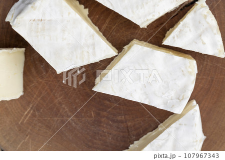 delicious white cheese sliced on a board 107967343