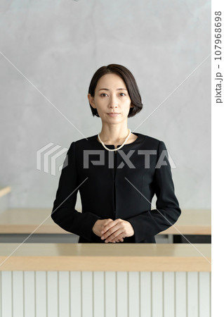 葬儀で手を合わせて祈る女性 葬儀で手を合わせて祈る女性 107968698