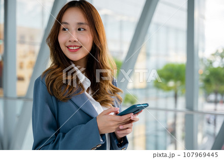 Hipster girl with smartphone in hand, typing text message for social networking and communication concept, close-up view of female hands, lifestyle woman working Hipster girl with smartphone in hand, typing text message for social networking and communication concept, close-up view of female hands, lifestyle woman working 107969445