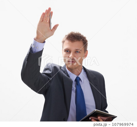 A businessman holds a hand up with a pen A businessman holds a hand up with a pen 107969974