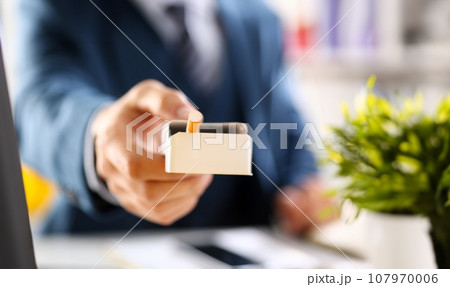 Male arm in suit offer pack of cigarettes Male arm in suit offer pack of cigarettes 107970006