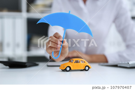 The female hand holds a miniature umbrella The female hand holds a miniature umbrella 107970407