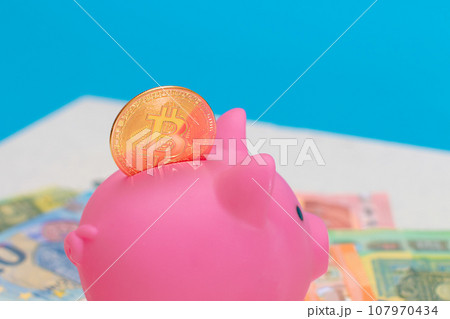Pink Piggy Bank with Bitcoin Coin on the Euro Banknotes 107970434