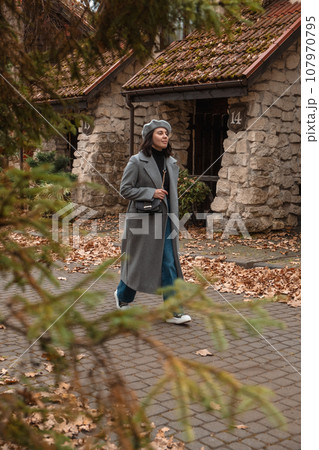 woman in autumn outfit walking by street woman in autumn outfit walking by street 107970795