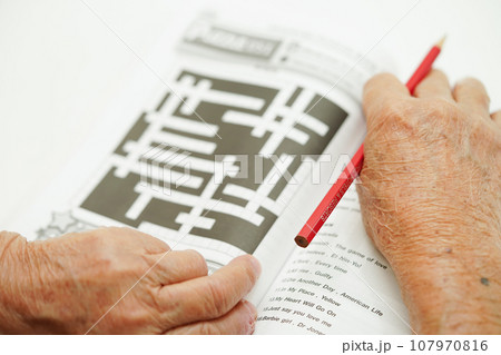 Asian elderly woman playing sudoku puzzle game for treatment dementia prevention and Alzheimer disease. 107970816